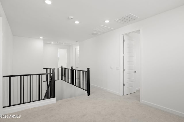 carpeted spare room featuring baseboards, recessed lighting, and visible vents