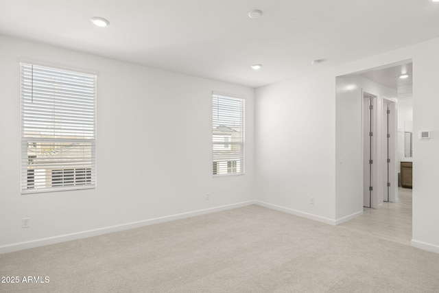 unfurnished room featuring baseboards, recessed lighting, and light carpet