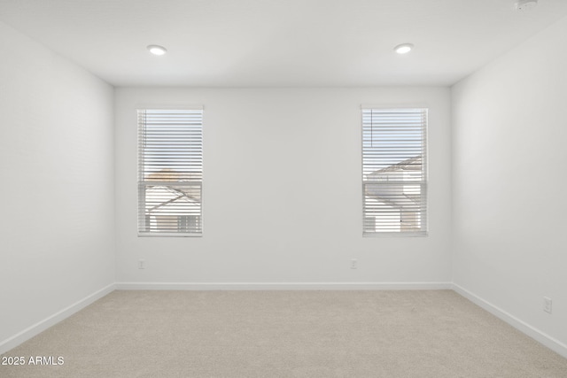 spare room with recessed lighting, baseboards, and light carpet