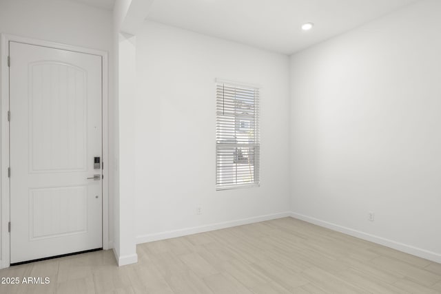 unfurnished room with recessed lighting and baseboards