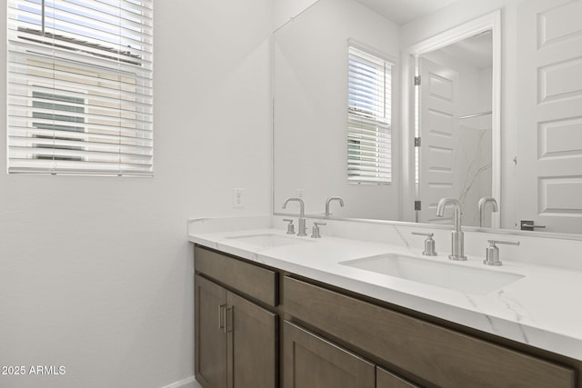 bathroom featuring double vanity, baseboards, and a sink