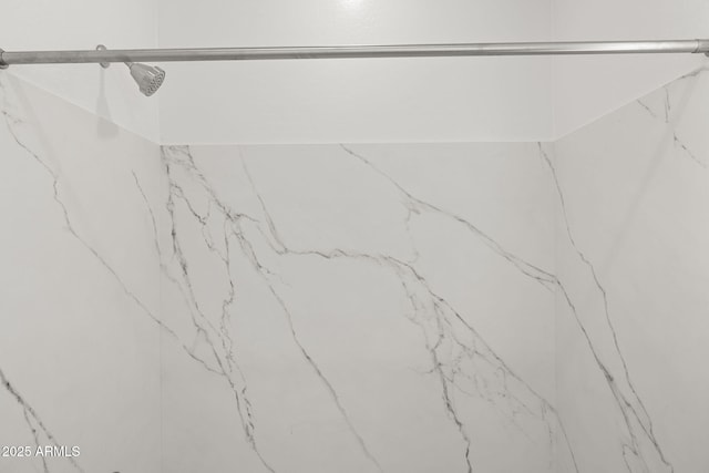 interior space featuring a marble finish shower