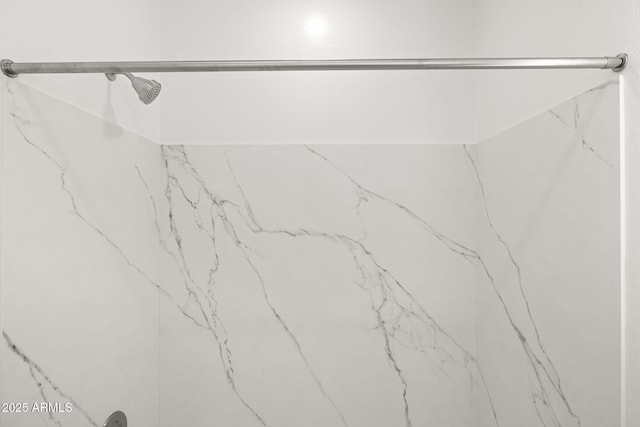 room details featuring a marble finish shower