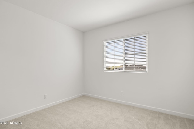unfurnished room with baseboards and light colored carpet