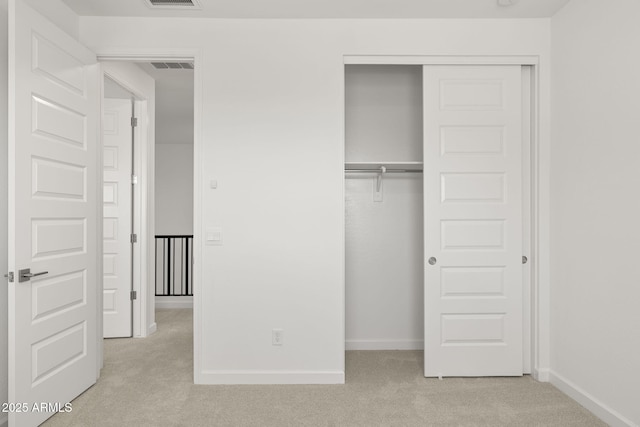 unfurnished bedroom featuring baseboards, visible vents, light carpet, and a closet