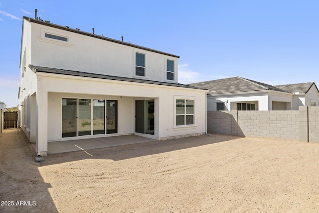 back of house with a fenced backyard, a patio area, and stucco siding