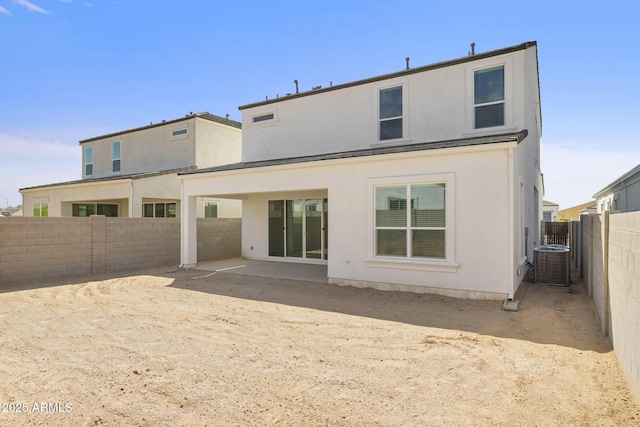 back of property featuring central AC unit, a fenced backyard, a patio area, and stucco siding