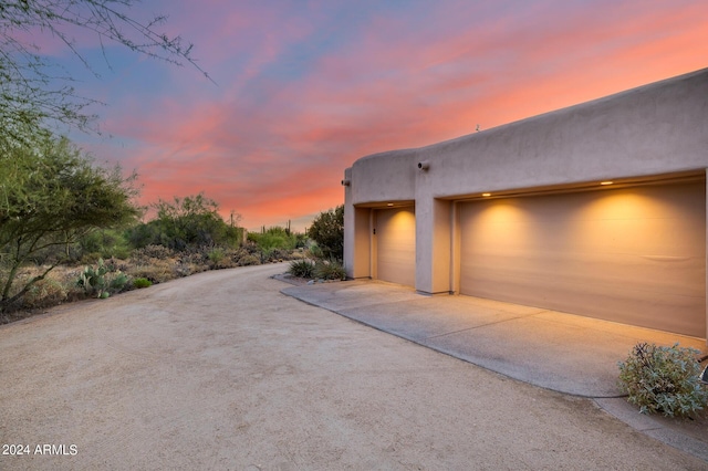 view of garage at dusk