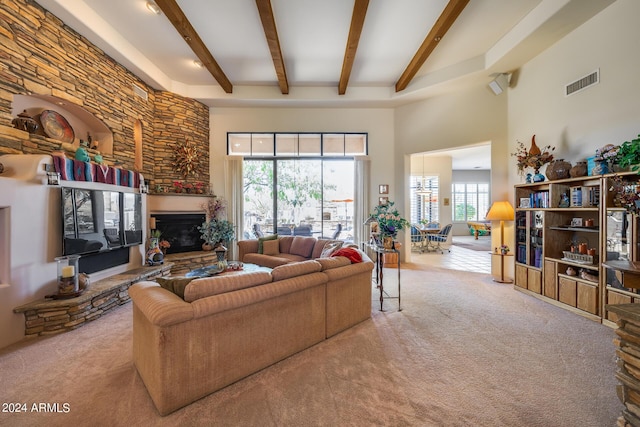 carpeted living room featuring beam ceiling, a towering ceiling, and a fireplace