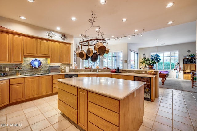 kitchen featuring backsplash, a kitchen island, decorative light fixtures, billiards, and wine cooler