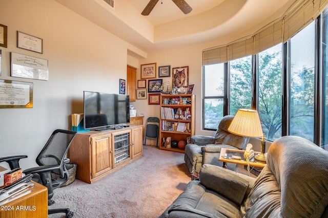 office featuring light colored carpet, a raised ceiling, and ceiling fan