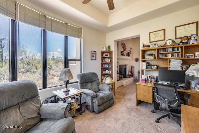 carpeted office space featuring ceiling fan