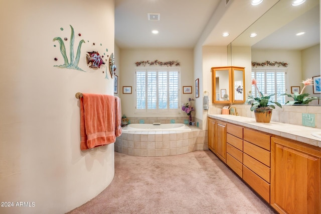 bathroom featuring tiled tub, a wealth of natural light, vanity, and decorative backsplash