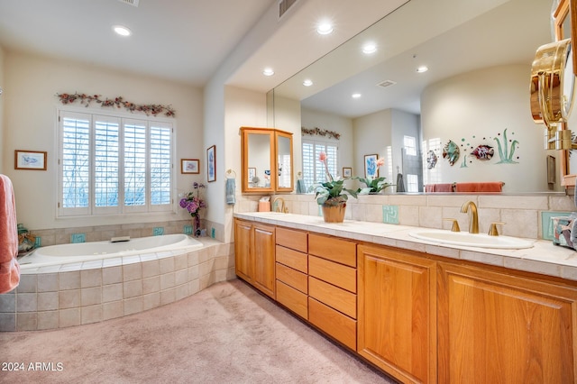 bathroom with vanity, tiled tub, and backsplash