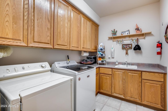 clothes washing area with washer and clothes dryer, cabinets, and sink