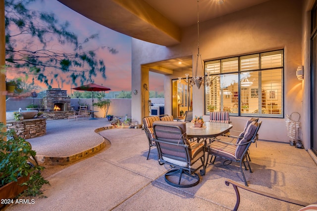 patio terrace at dusk with an outdoor stone fireplace