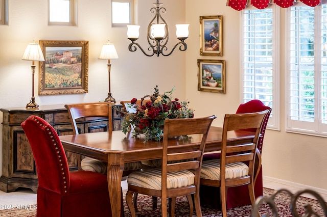 dining room featuring baseboards and a notable chandelier