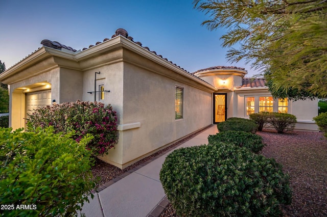 view of home's exterior featuring a tile roof and stucco siding