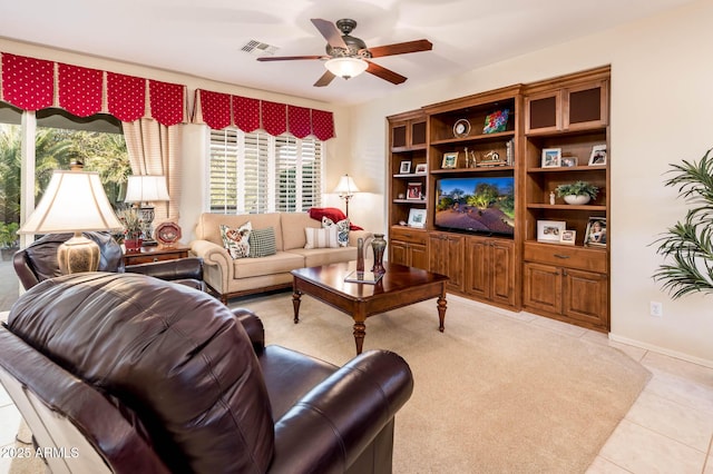 living area featuring a ceiling fan, visible vents, and light tile patterned floors