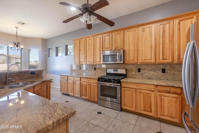 kitchen with sink, decorative light fixtures, light tile patterned floors, stainless steel appliances, and decorative backsplash