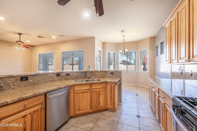 kitchen featuring sink, hanging light fixtures, stainless steel appliances, a wealth of natural light, and ceiling fan with notable chandelier