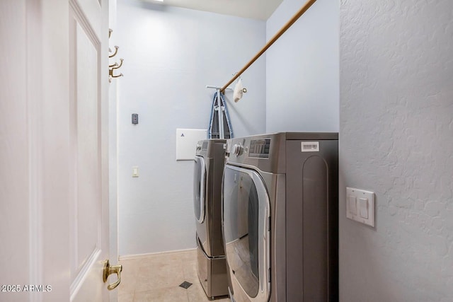 washroom featuring washer and clothes dryer and light tile patterned flooring