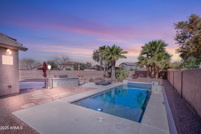 pool at dusk featuring a patio