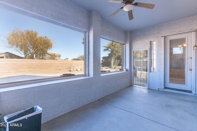 unfurnished sunroom featuring ceiling fan