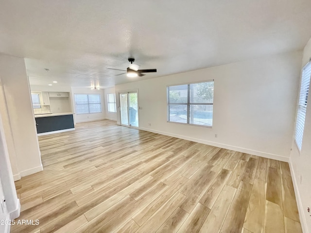 unfurnished living room with ceiling fan and light hardwood / wood-style flooring