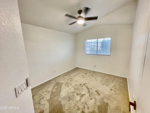 carpeted empty room featuring vaulted ceiling and ceiling fan