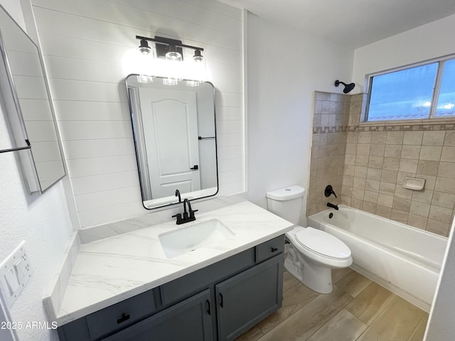 full bathroom featuring vanity, toilet, tiled shower / bath combo, and hardwood / wood-style floors