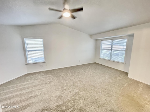 empty room with lofted ceiling, carpet floors, and ceiling fan