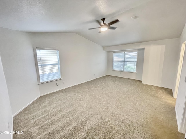 carpeted empty room with vaulted ceiling, a textured ceiling, and ceiling fan