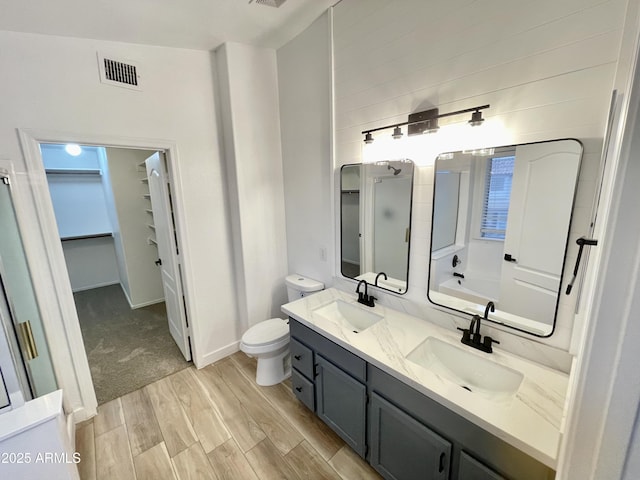 full bathroom with wood-type flooring, separate shower and tub, vanity, and toilet