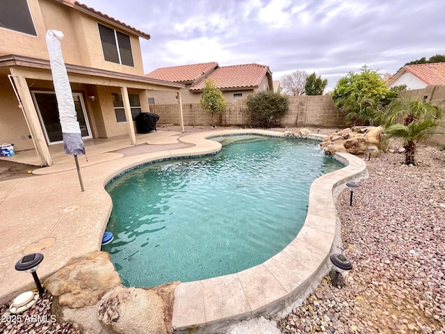 view of pool with grilling area, a patio area, and pool water feature