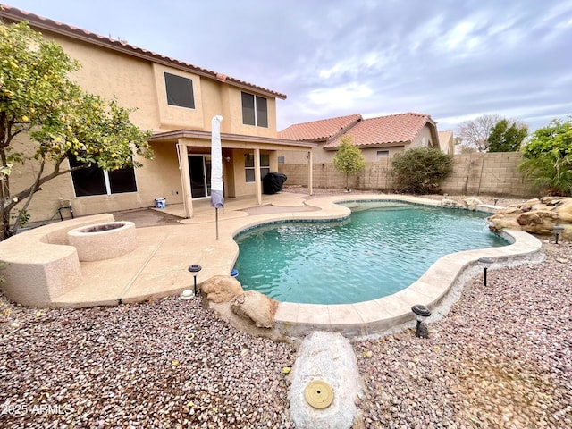 view of swimming pool with an outdoor fire pit and a patio