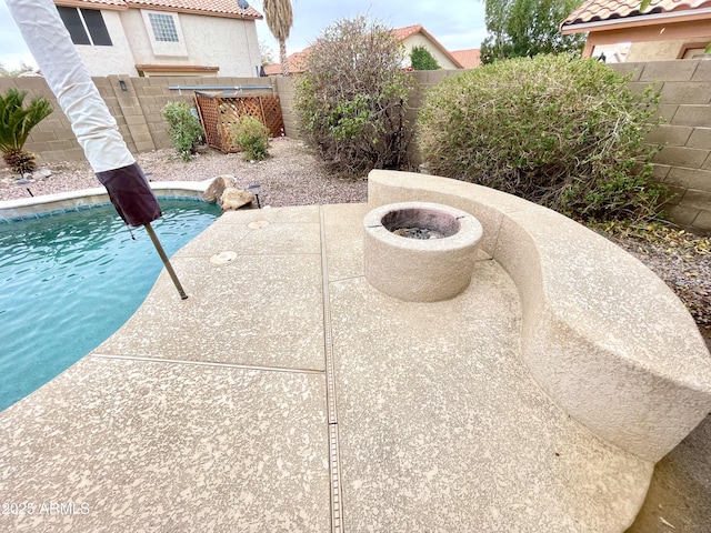 view of swimming pool with a patio area and a fire pit