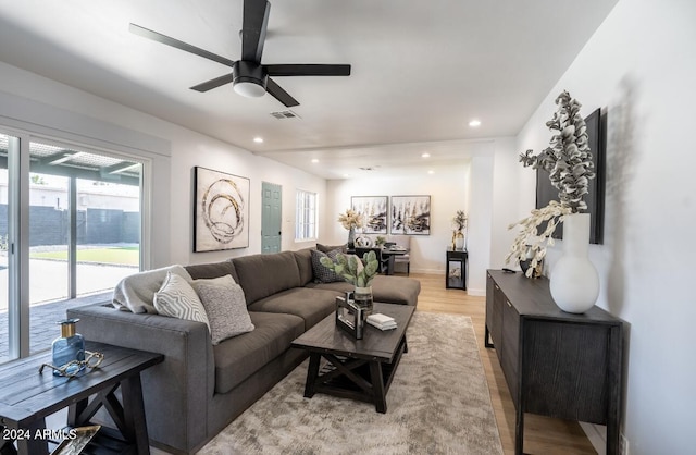 living room featuring ceiling fan and light hardwood / wood-style floors