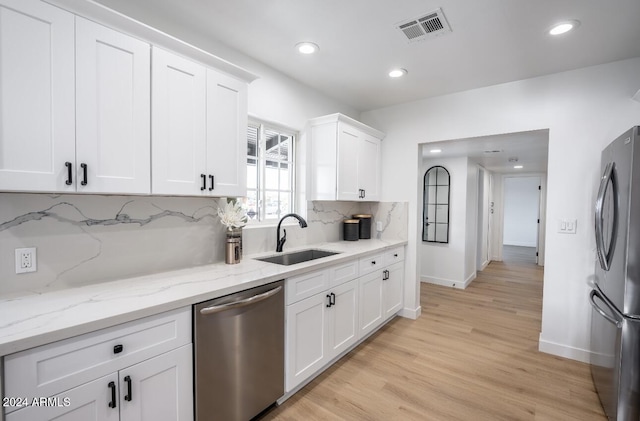 kitchen with white cabinets, light hardwood / wood-style floors, sink, and appliances with stainless steel finishes