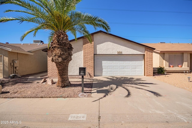 view of front of home featuring a garage, brick siding, driveway, and stucco siding