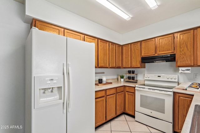 kitchen with light countertops, white appliances, brown cabinets, and under cabinet range hood