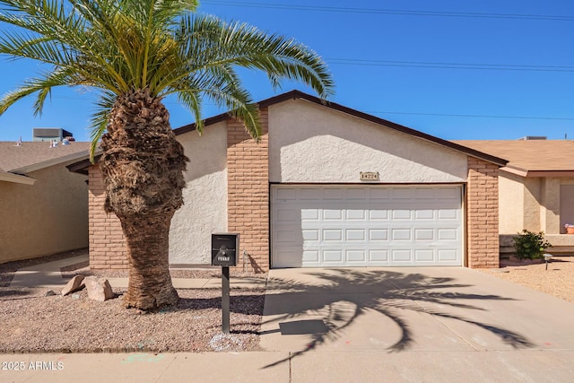 view of front of property with a garage, concrete driveway, brick siding, and stucco siding