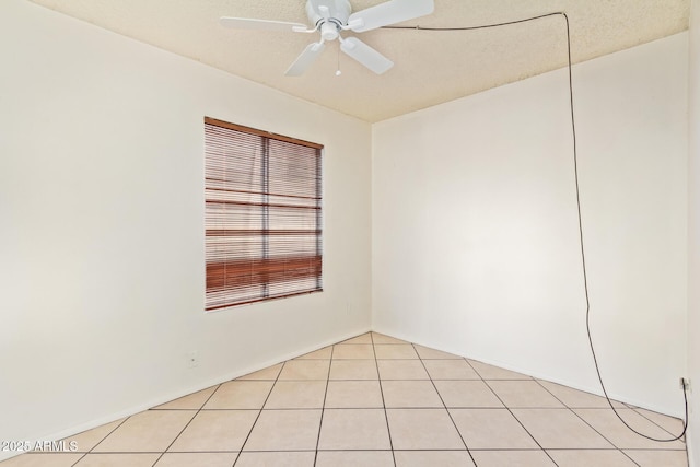 spare room featuring light tile patterned flooring, ceiling fan, and a textured ceiling