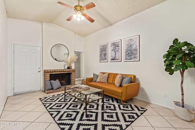 living room featuring light tile patterned floors, ceiling fan, vaulted ceiling, a textured ceiling, and a fireplace