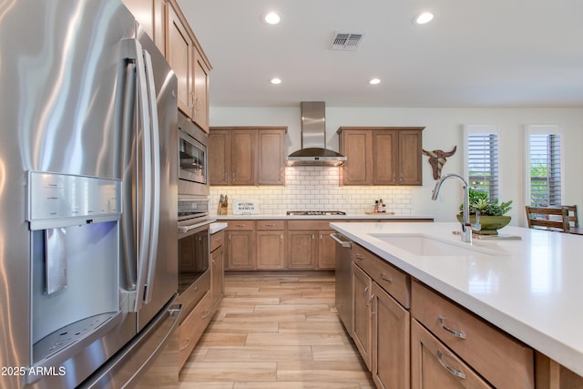 4350 Stage Stop Way, Wickenburg, AZ 85390 - kitchen featuring stainless steel appliances, wall chimney range hood, a sink, light countertops, and light wood-type flooring