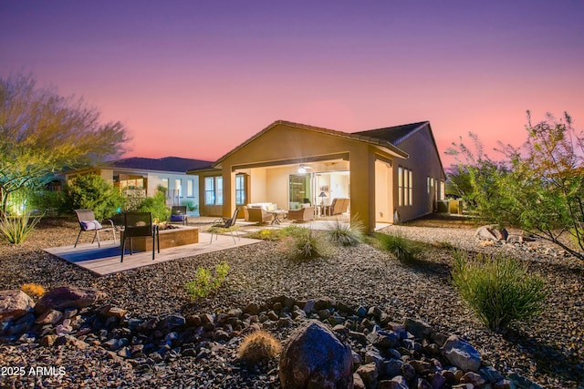 4350 Stage Stop Way, Wickenburg, AZ 85390 - back of property at dusk featuring an outdoor living space, a patio area, and stucco siding