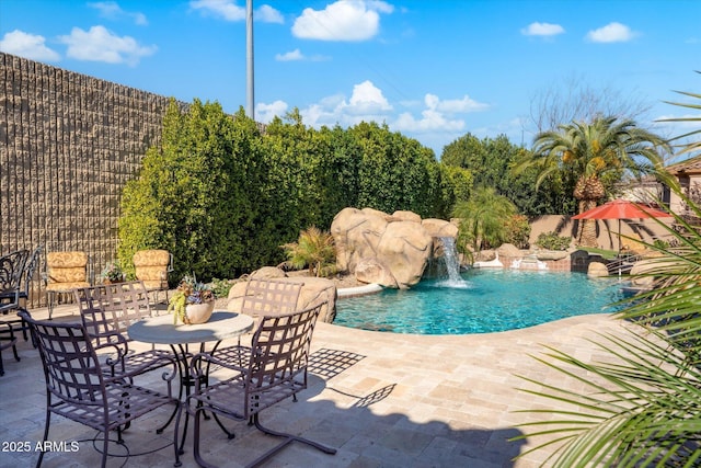 view of pool featuring pool water feature and a patio