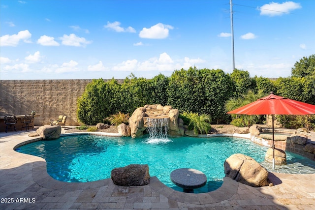 view of swimming pool with pool water feature and a patio