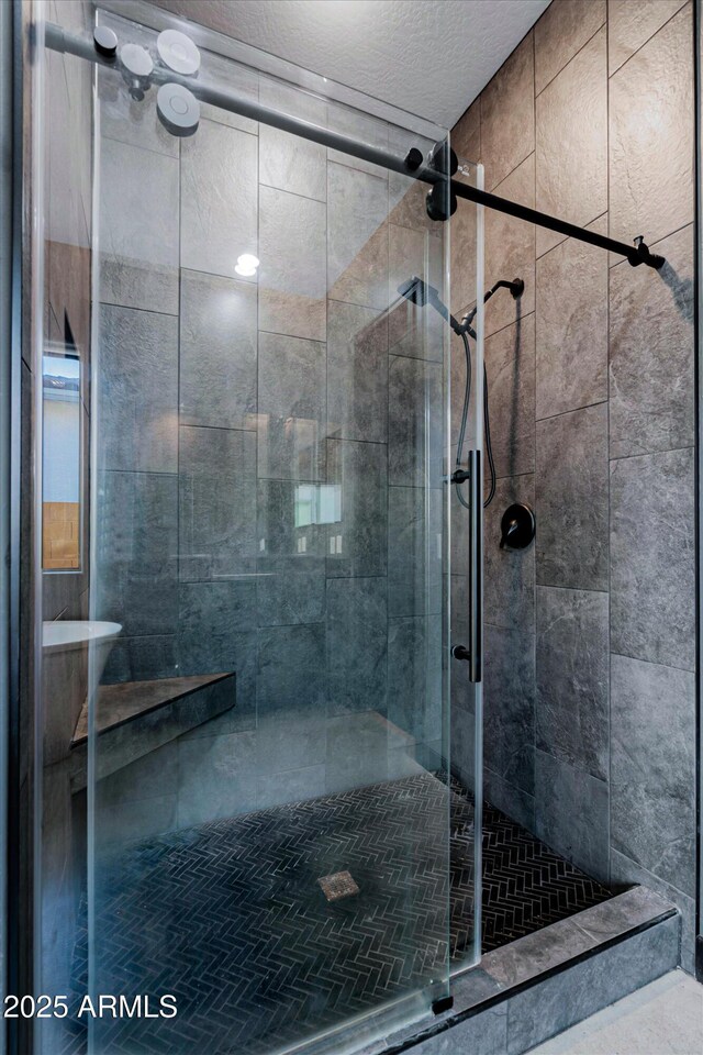 bathroom with a textured ceiling and an enclosed shower