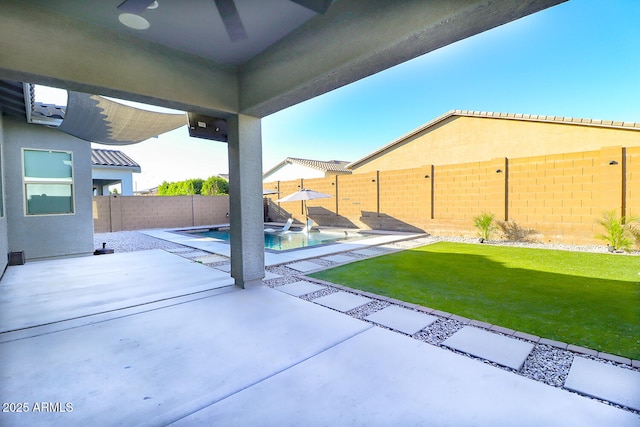 view of patio / terrace featuring a fenced in pool and ceiling fan